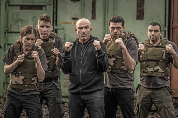 istock Krav Maga fighting group posing for team picture in grimy outdoor setting 913094600
