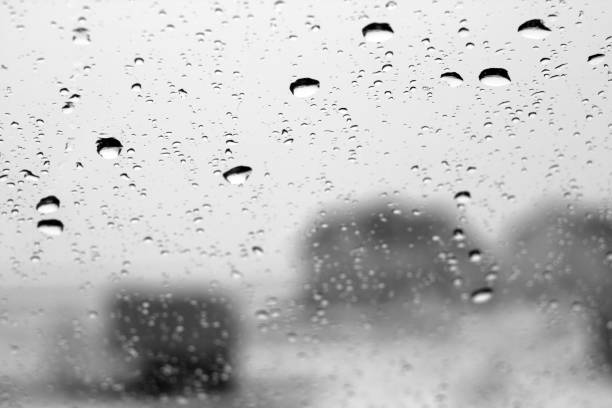 istock Winter view through window with focus on rain drops in black and white. 913098086