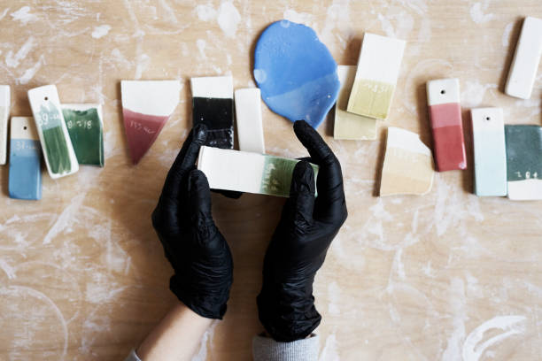 istock Samples of colored enamel for color ceramic in hands, working process in studio, clay, wood, craft 913098774