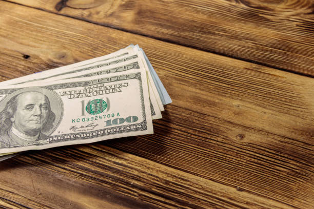 istock Stack of one hundred dollars bills on wooden desk 913105740