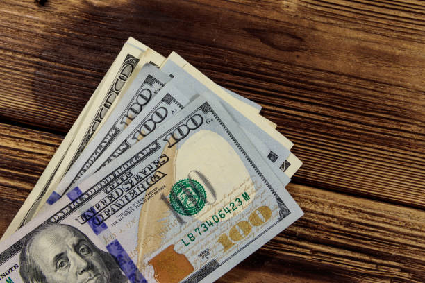 istock Stack of one hundred dollars bills on wooden desk 913105742