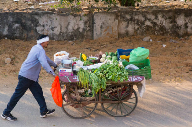 Man using handcart to sell vegetables stock photo