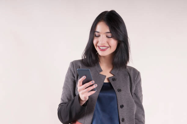 istock young beautiful businesswoman with phone smiling braces studio 913112652