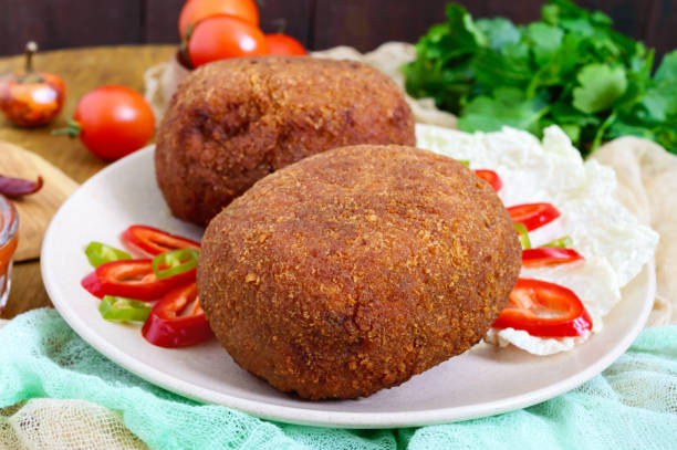 istock Juicy golden cutlets stuffed with boiled egg on a wooden background. 913113418