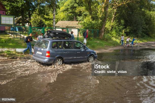 Coche En Movimiento En Charco Después De La Lluvia En Asador Del Mar Báltico Foto de stock y más banco de imágenes de Agua