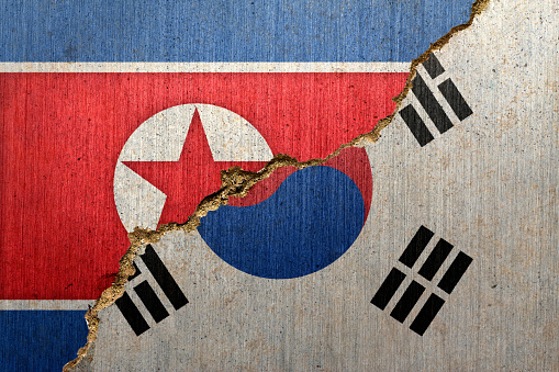 Flags of North and South Korea on a Creacked Concrete Background