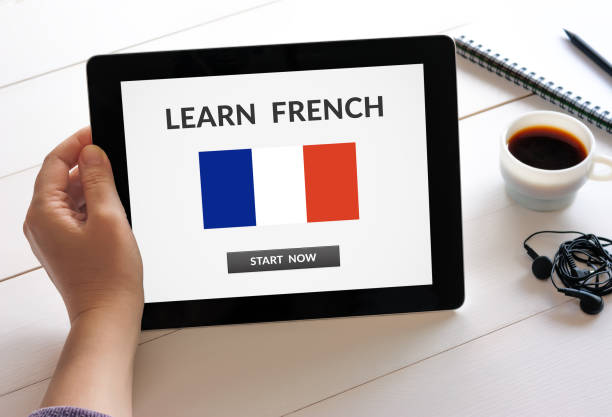 hand holding tablet with learn french concept on screen - photography starbucks flag sign imagens e fotografias de stock