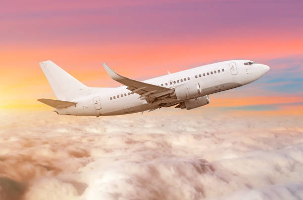 istock Flying airplane above the clouds horizon sky with bright sunset colors. 913131594