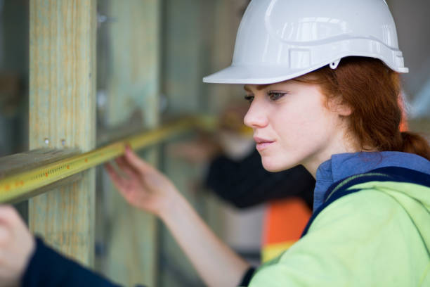 巻尺で測定現場の若い女性大工 - construction young adult architect women ストックフォトと画像