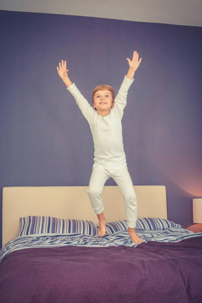 istock Playful boy jumping on the bed. 913171816