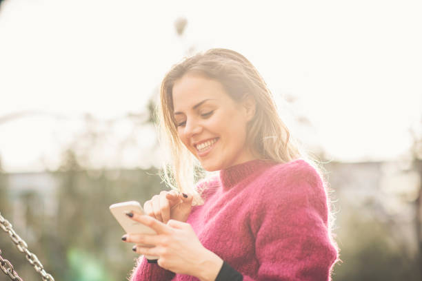 istock Sweet woman in the park using her cell phone 913183356