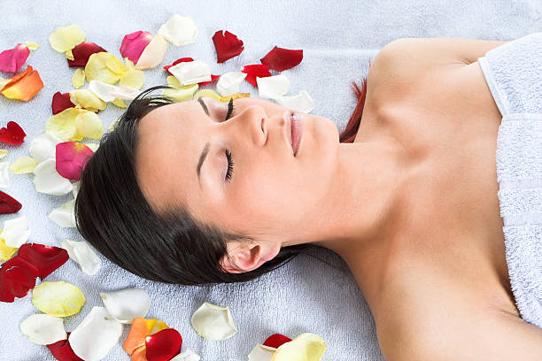 istock Brunette laying on the blue towel with petals spread around 91318738