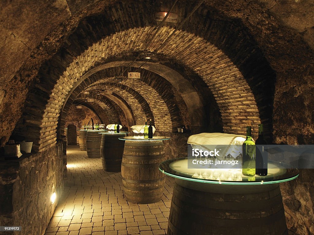 Wine barrels in the old cellar of a winery. Wine barrels in the old cellar of the winery. Wine Cellar Stock Photo