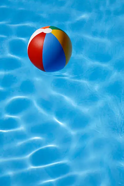 Colorful beachball floating in bright blue pool