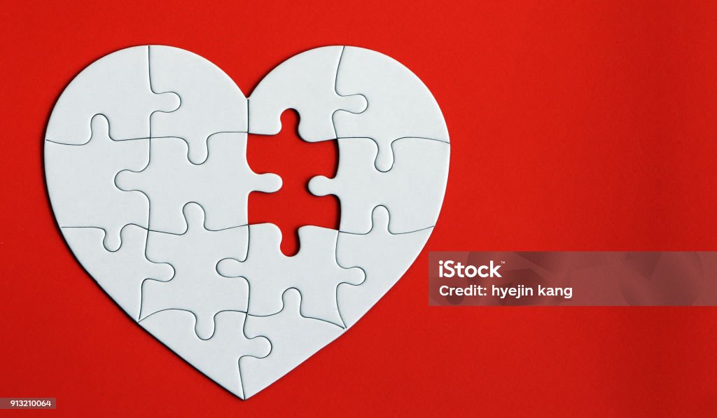 Heart puzzle on the red background. A missing piece of the heart puzzle. Blood Donation Stock Photo