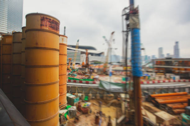 A large construction site in the city, the process of massive buliding construction with heavy vehicle at work, excavator, elevating crane and bulldozer