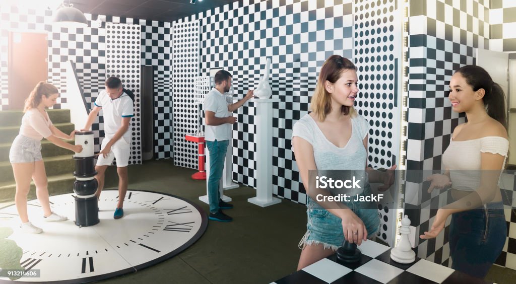 Five adults solving different conundrum in quest room Five positive british adults solving different conundrum in quest room Adulation Stock Photo