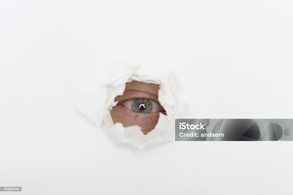 Occhio nel buco di carta bianca - Foto stock royalty-free di Accudire