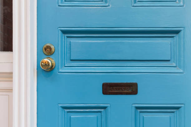 Front blue door, detail and closeup Blue front door detail shot showing the door knob, door lock and the mail slot handle stock pictures, royalty-free photos & images