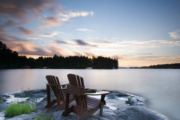 istock Adirondack chairs facing a lake at sunset 913245946