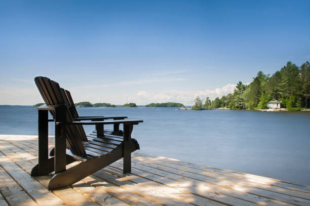istock Adirondack chairs facing a calm lake 913246048