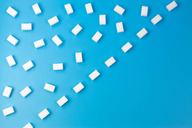 istock White sugar cubes arranged in diagonal lines on blue background 913260490