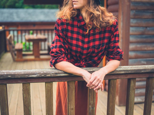 femme, reposante sur la véranda - lumberjack shirt photos et images de collection