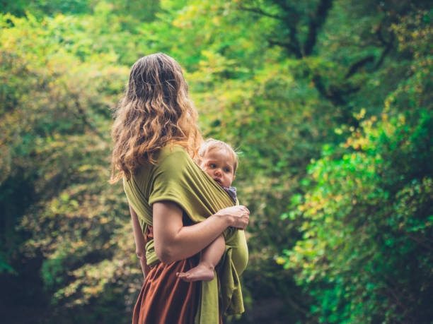 istock Mother with baby in sling in nature 913264532