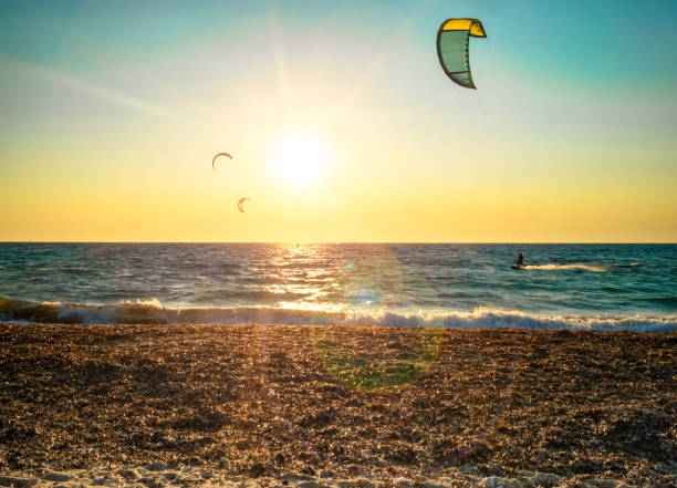 istock kitesurfers and sunset flare 913268136
