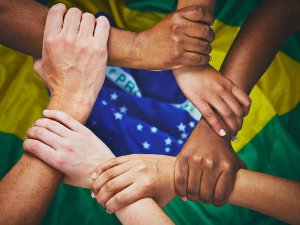 istock Six linked hands over Brazilian national flag 913268360