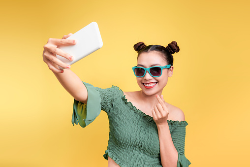 Young cheerful attractive asian woman taking selfies with smile.