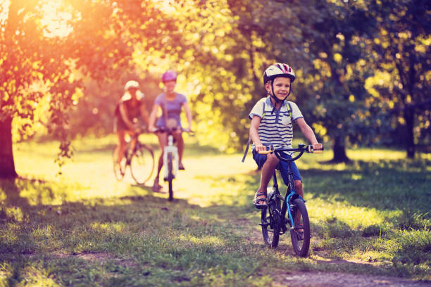 istock Family riding bicycles in park 913268536