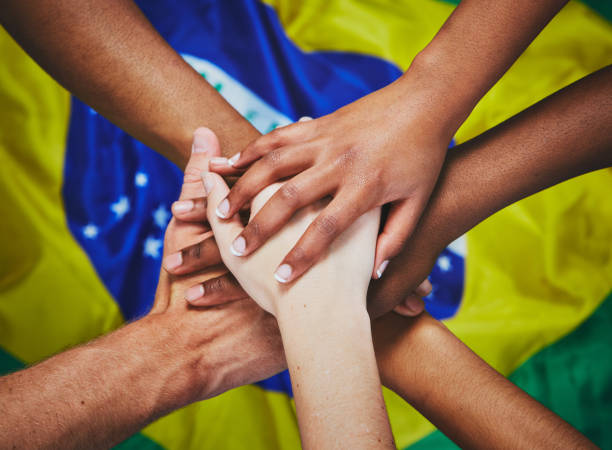 istock Mixed hands piled up over Brazilian flag 913268888