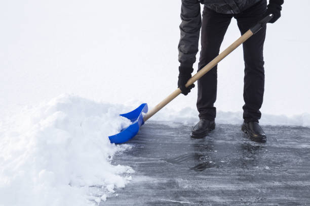 istock Man cleaning snow with blue shovel from ice surface for ice skating. Winter routine concept. 913271068