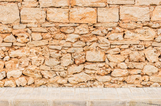 istock Street with old stone wall background 913272234