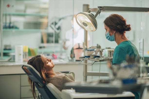 istock Female dentist talking to her patient at dentist's office. 913275706