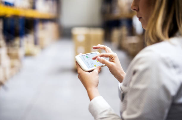 istock Woman warehouse worker with smartphone. 913276150