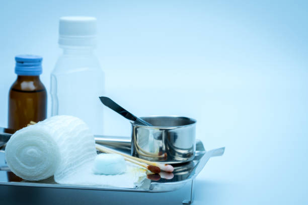 Wound care dressing set on stainless steel plate. Cotton ball with alcohol, cotton stick with povidone-iodine, forceps and conform bandage. Wound care dressing set on stainless steel plate. Cotton ball with alcohol, cotton stick with povidone-iodine, forceps and conform bandage. saline drip stock pictures, royalty-free photos & images