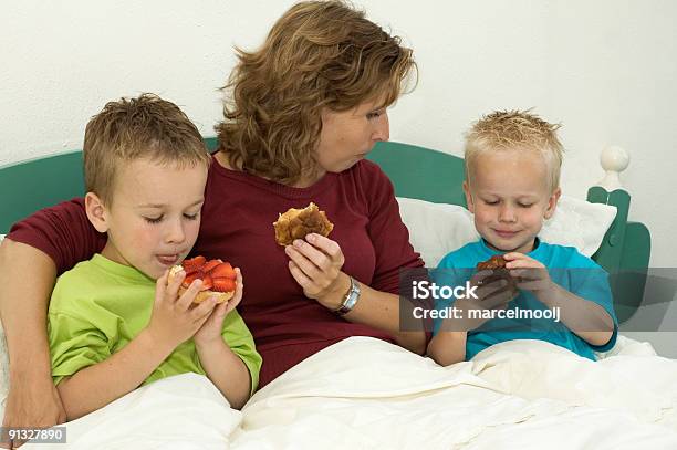 Comer Un Pan De Pasas Foto de stock y más banco de imágenes de Cama - Cama, Niño, Abrazar