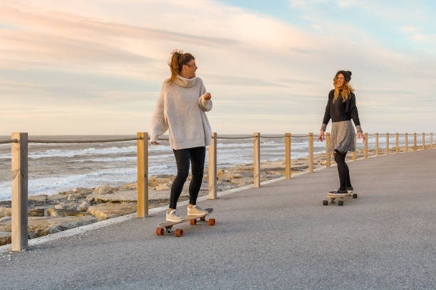 istock Two female friends playing with skateboard 913279062