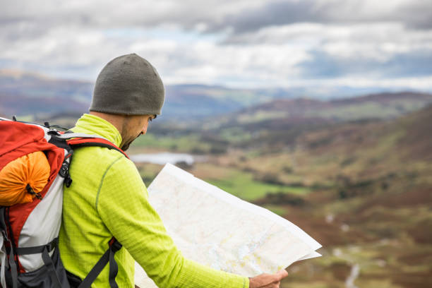 istock Man explorer looking a map at top of mountain hiking trail 913281240