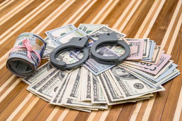 наручники с долларовых купюр на столе. заживать - bail стоковые фото и изображения