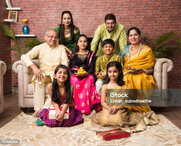 Retrato De Familia Feliz India En Ropa Tradicional Sentado En El Sofá De Interior Foto de stock y más banco de imágenes de Familia