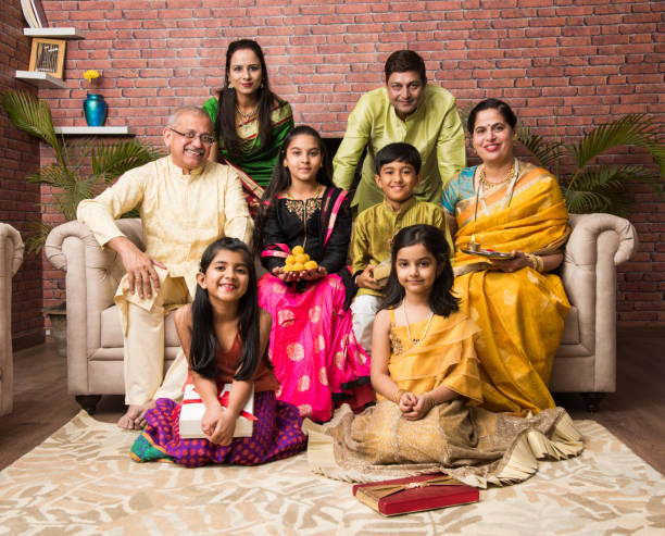 Portrait of happy Indian family in traditional wear sitting on sofa indoor Portrait of happy Indian family in traditional wear sitting on sofa indoor traditional clothing photos stock pictures, royalty-free photos & images