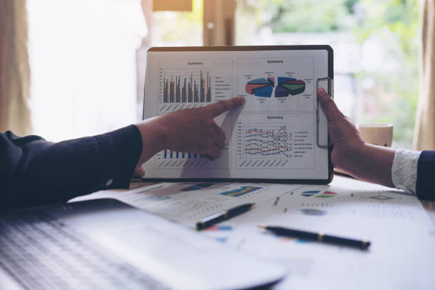 istock financial Image of  business people pointing at business document presentation summary report , during discussion at meeting , Notebook on wood table 913295940