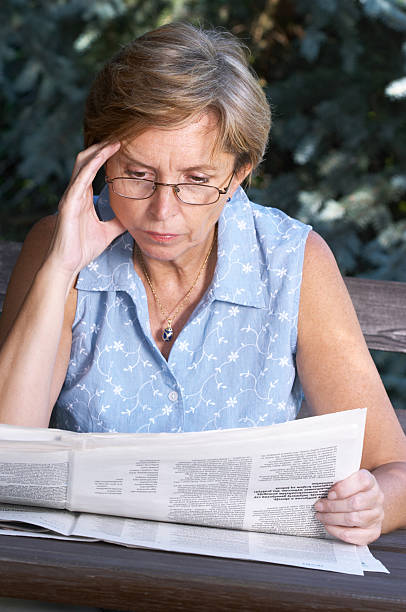 istock Middleaged woman reading newspaper 91329854