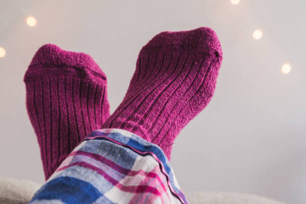 istock Feet up in pink socks crossed over each other 913303468