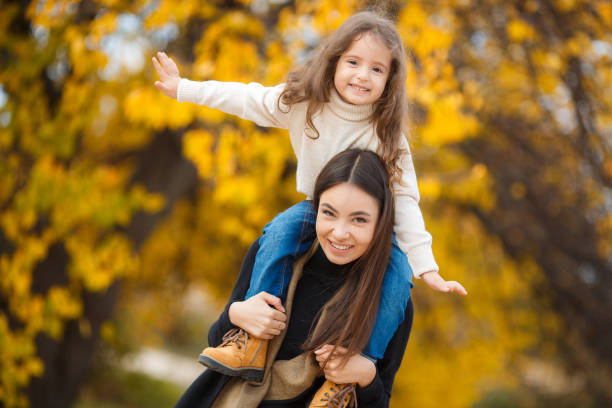 linda jovem mãe com sua filha no outono park - little girls autumn child red hair - fotografias e filmes do acervo