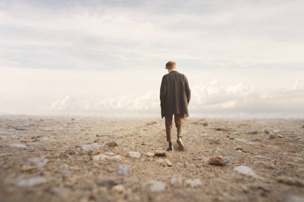 istock lonely man walks towards an unknown destination in a desert landscape 913304330
