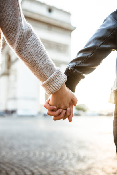 istock couple holding hands at arch du triomphe 913307736